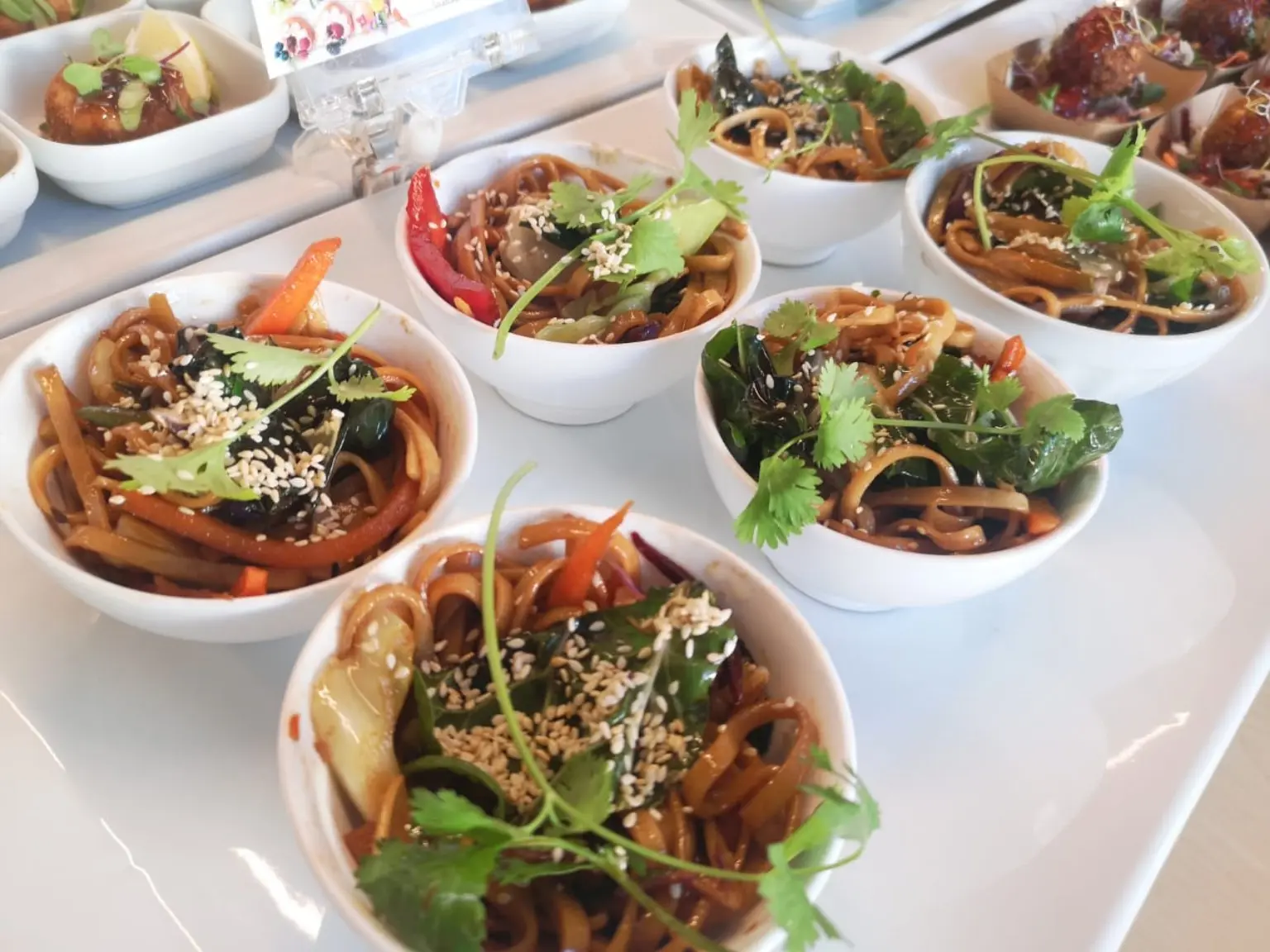 Individual noodle bowls prepared for a catered service